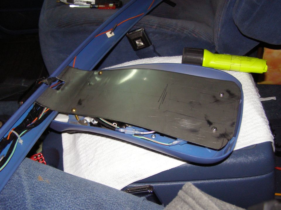 Overhead console part with exposed wires and a yellow flashlight