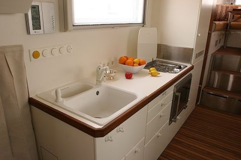 1993 Ford Bronco - Interior view of an RV kitchen area a sink, stovetop, and microwave.