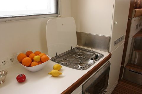 1993 Ford Bronco - The interior of an RV shows a compact kitchenette area with a stovetop and a bowl of oranges and lemons.