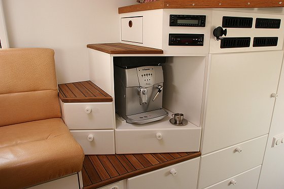 Interior view of a vehicle with a built-in coffee maker and tan leather seat