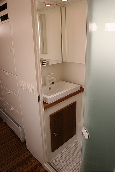 1993 Ford Bronco - Interior view of an RV's compact bathroom a sink, mirror, and storage cabinets.