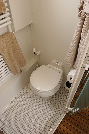 1993 Ford Bronco - Interior view of a bathroom with a toilet, towel rack, and toilet paper holder.