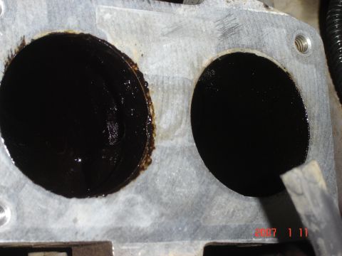 1993 Ford Bronco - The throttle body openings are coated in thick, black residue.