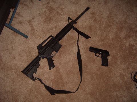 1988 Ford Bronco - An assault rifle and a handgun are placed on a carpeted surface next to a table leg.