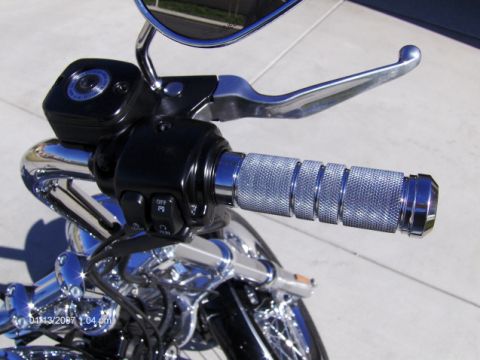 2004 Ford Crown Victoria - Close-up of a motorcycle's handlebar chrome grips and a brake lever, with a date stamp visible in the corner.