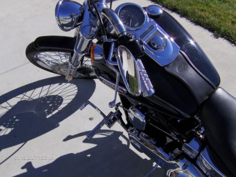 2004 Ford Crown Victoria - A motorcycle is parked on a concrete surface, casting a shadow.