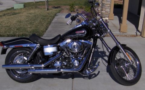 2004 Ford Crown Victoria - A black motorcycle with chrome accents and flame decals is parked on a paved surface.