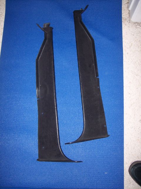 1972 Ford Ranchero - Two black plastic interior trim pieces are laid out on a blue mat.