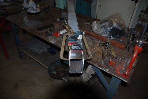 1996 Ford Bronco - Workbench setup with a metal part secured by clamps and various tools.