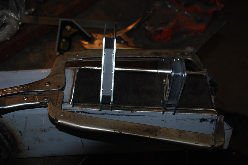 Metal panel being clamped and measured for repair