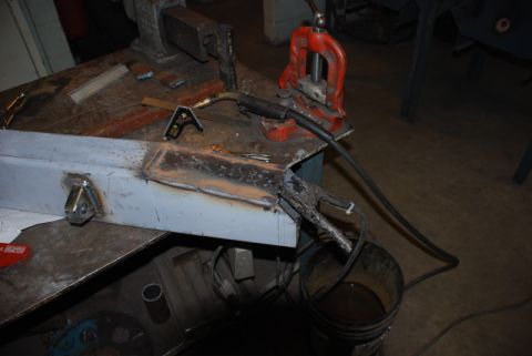 1996 Ford Bronco - Metal fabrication in progress with welding equipment and various parts on a workbench.