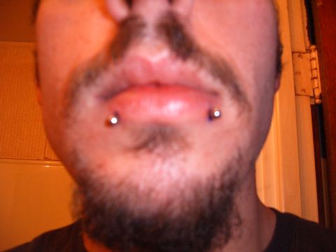 1993 Ford Bronco - A close-up view of a person's face, highlighting their lip and chin piercings.