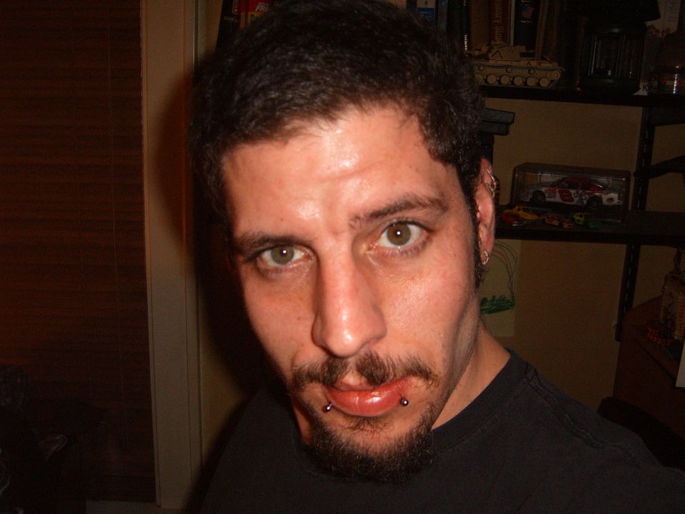 Close-up portrait of a person indoors with shelves of diecast models behind