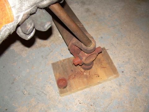 1988 Ford Bronco - Close-up of a driveshaft universal joint assembly being held by a gloved hand.