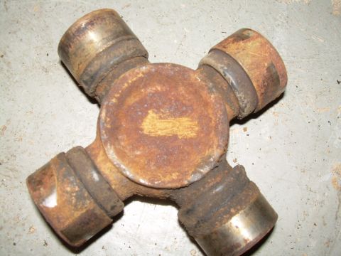 1988 Ford Bronco - A heavily rusted universal joint with visible yellow markings on its central body.