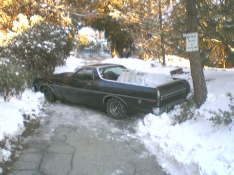 1973 Ford Ranchero - A black 1973 Ford Ranchero is parked on a snow-covered driveway, with snow chains on its rear tires.
