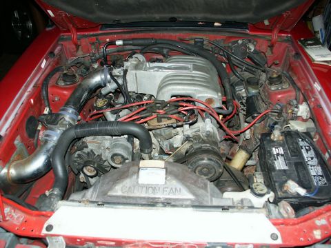1990 Ford Mustang - Engine bay view showing the V8 engine components and associated wiring and hoses.