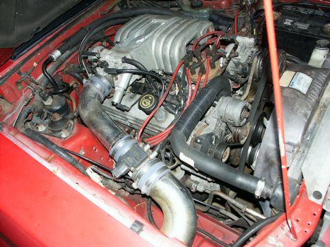 1990 Ford Mustang - The engine bay of a 1990 Ford Mustang is visible, the V8 engine and associated components.