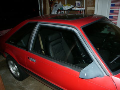 1990 Ford Mustang - This red 1990 Ford Mustang coupe features a sunroof and is viewed from a three-quarter front angle.