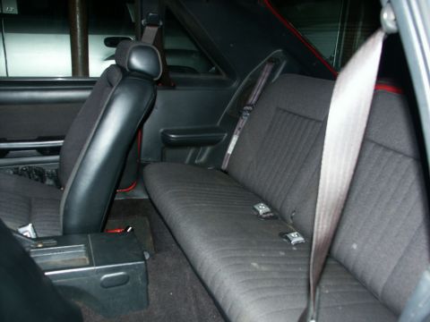 1990 Ford Mustang - The rear seats and center console of a car are visible in this interior photograph.