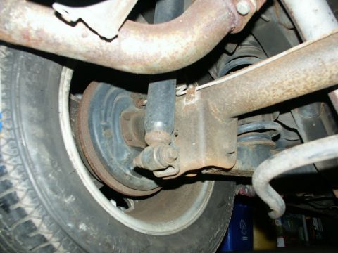 1990 Ford Mustang - Underside view of a vehicle's rear suspension components, including the wheel and shock absorber.