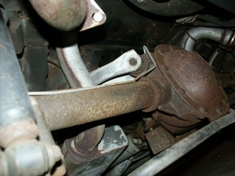 1990 Ford Mustang - Undercarriage view of corroded exhaust system parts and suspension components.