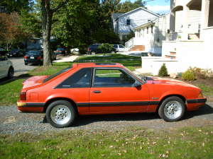 1990 Ford Mustang - Side profile of an orange 1990 Ford Mustang coupe.