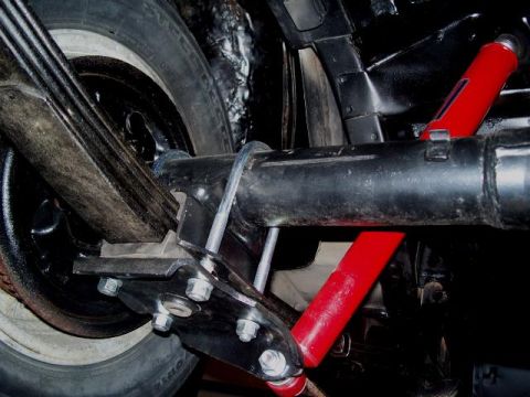 1971 Ford Ranchero - Close-up of the rear suspension system on a 1971 Ford Ranchero, showing leaf springs and red shock absorbers.