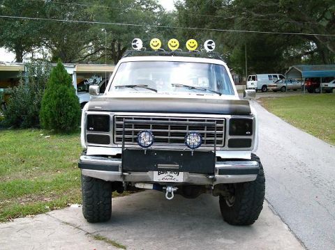 1986 Ford Bronco - This modified Ford Bronco features a custom grille guard and auxiliary lighting, including smiley face covers on the roof lights.