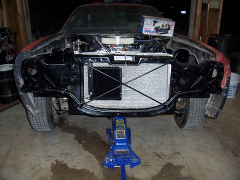1979 Chevrolet Camaro - Front view of a red Chevrolet Camaro undergoing repairs, with its engine and radiator visible.