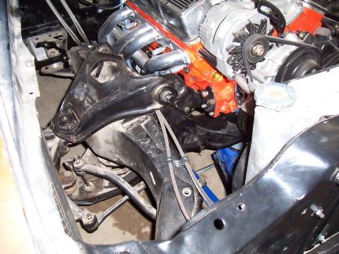 1979 Chevrolet Camaro - Close-up view of an engine bay an orange engine block, chrome headers, and visible suspension parts.