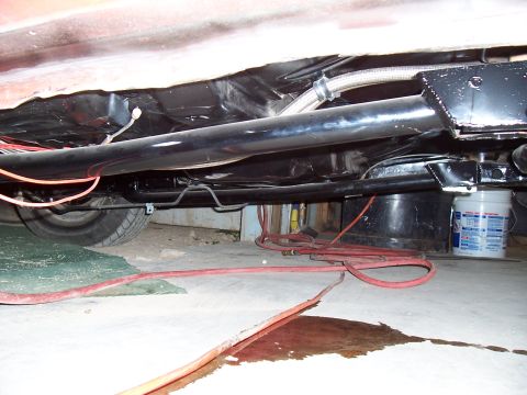 1979 Chevrolet Camaro - The underside of a vehicle reveals its exhaust system and fuel lines, with a tire visible in the background.