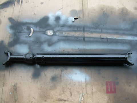 1988 Ford Bronco - A black driveshaft is shown lying on a surface with spray paint marks.