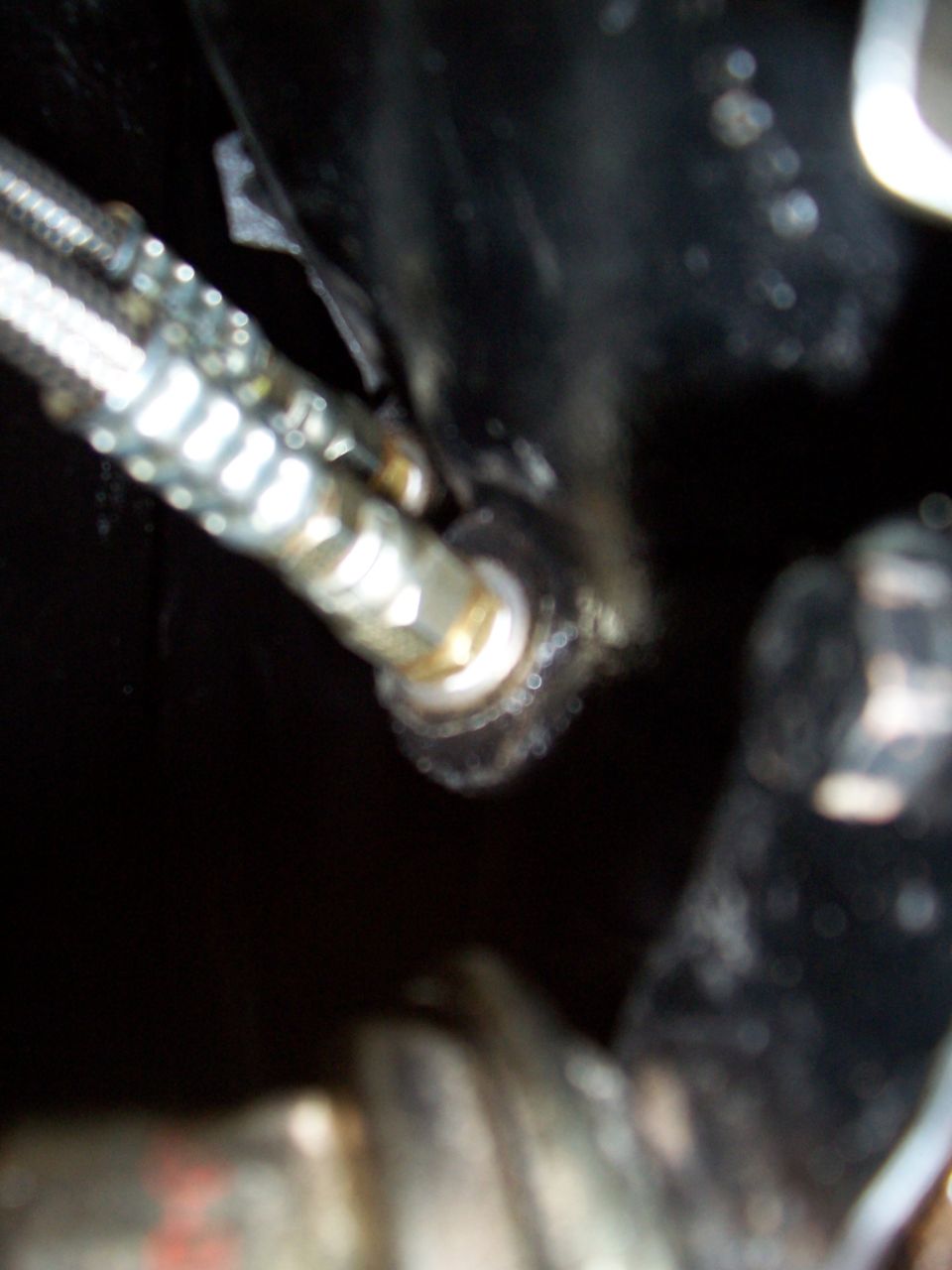 Close-up of a brake line fitting with braided hose