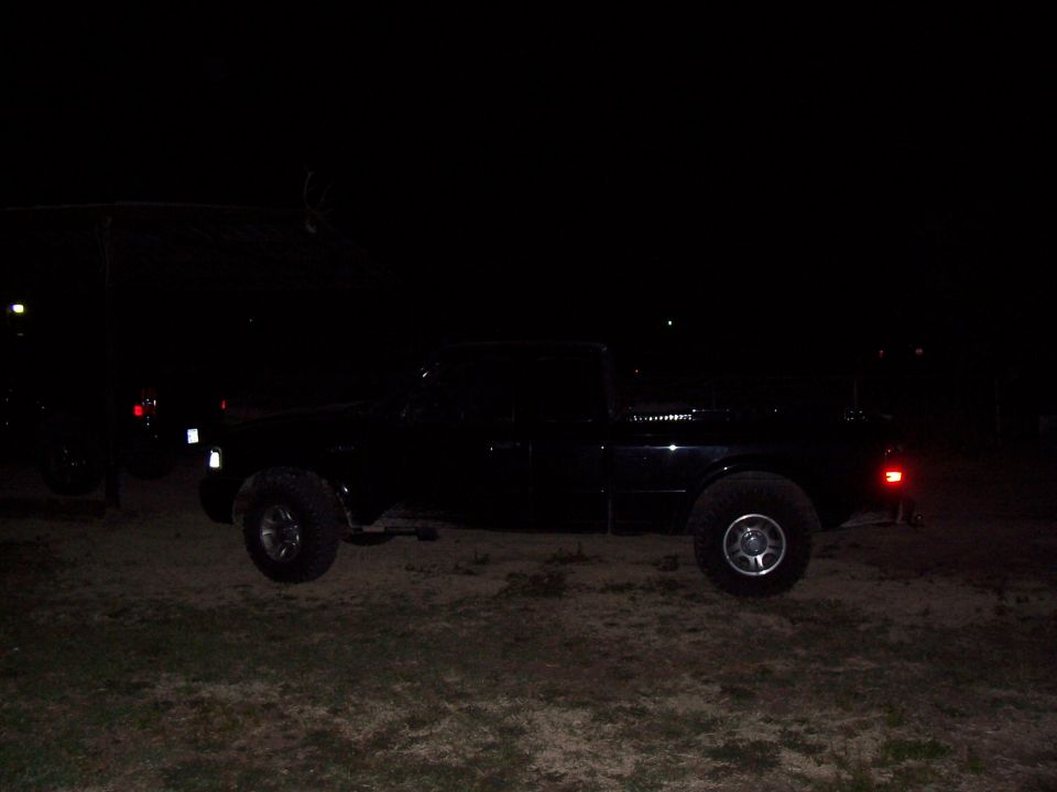 black pickup truck parked on dirt at night