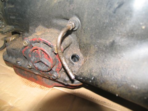 1978 Ford Bronco - Close-up view of a transmission component, showing a red-capped fitting and a metal line.