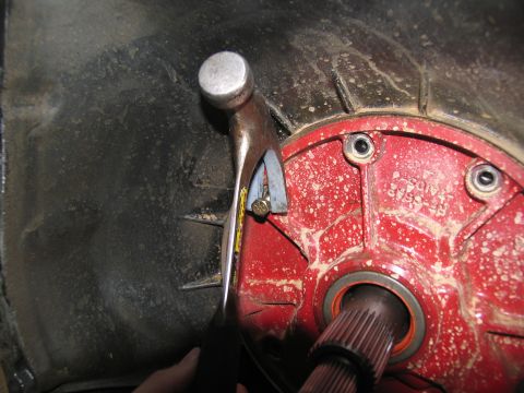 1978 Ford Bronco - Close-up of a hammer on a transmission housing, likely during a repair or tear-down.