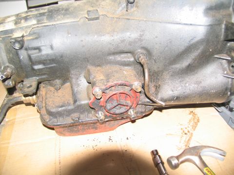 1978 Ford Bronco - Transmission housing detail, likely from a Ford vehicle, with a red part bolted on.