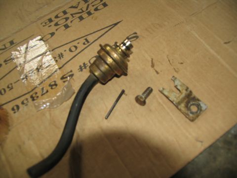 1978 Ford Bronco - Disassembled transmission component with associated hardware laid out on a cardboard surface.