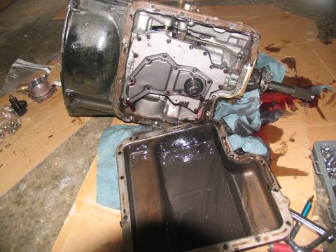 1978 Ford Bronco - Transmission pan removed, revealing internal components and accumulated grime from used transmission fluid.