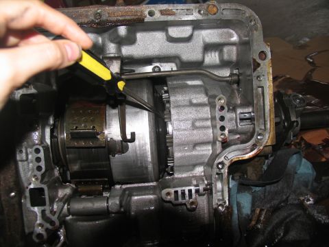 1978 Ford Bronco - Working on the transmission internals with a screwdriver.