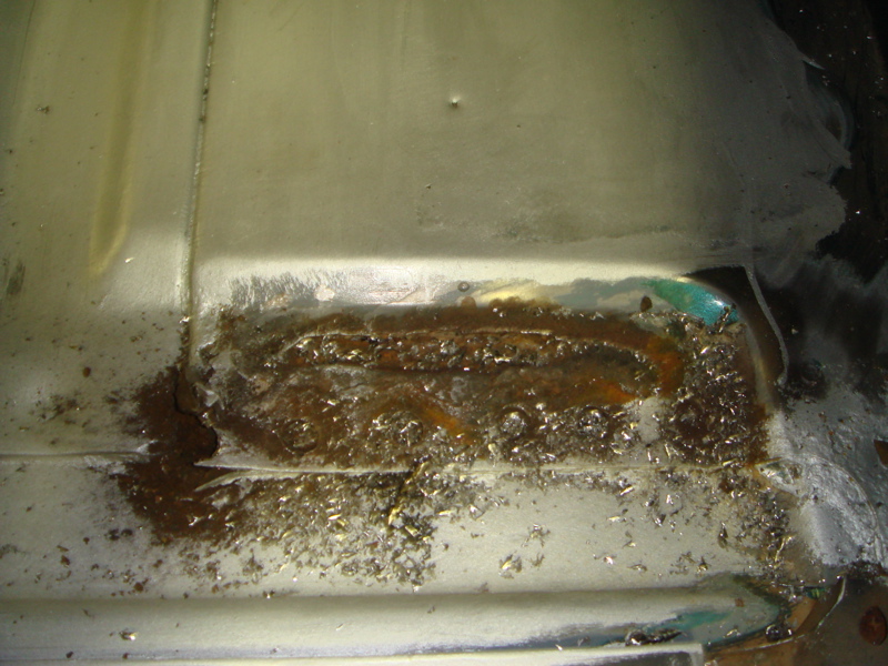 Close-up of a corroded metal section with rust and debris