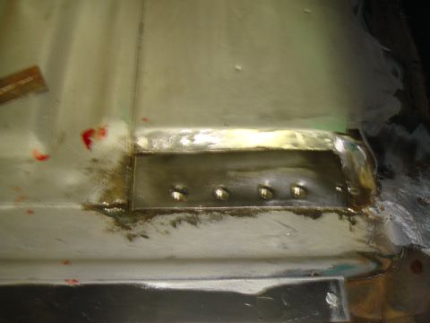 1996 Ford Bronco - Close-up of a metal patch being welded onto a vehicle's floor, showing repair work.