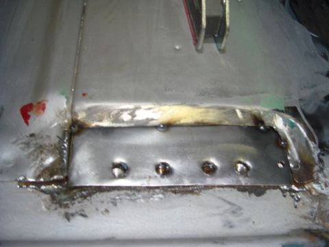 1996 Ford Bronco - Close-up of a metal patch repair on a vehicle's floor, showing welding and rivets.