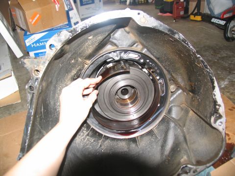 1978 Ford Bronco - Disassembled transmission housing with a hand holding a clutch pack.