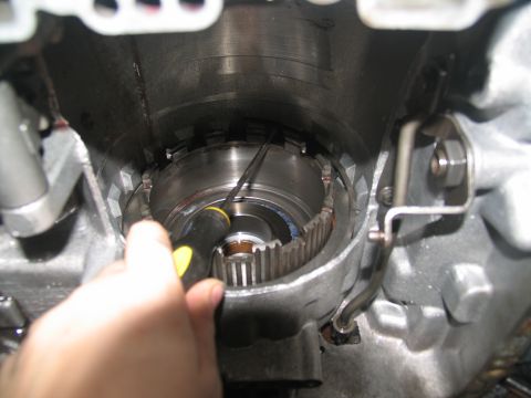 1978 Ford Bronco - Close-up view of internal transmission components, with a hand holding a screwdriver to adjust a part.