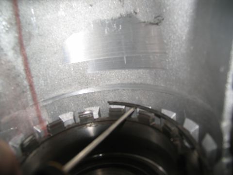 1978 Ford Bronco - A tool is used to manipulate a metal band inside a transmission drum.