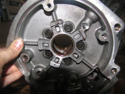 1978 Ford Bronco - A hand holds a metal transmission part, revealing internal components and bolt patterns.