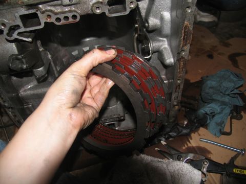 1978 Ford Bronco - A transmission clutch pack, showing its layered friction discs, is held for inspection.