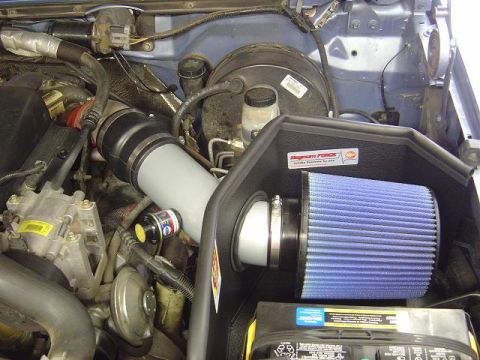 1986 Ford Bronco II - Close-up of an engine bay showing an aftermarket air intake system with a blue filter.